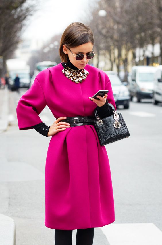 a fuchsia coat and a statement necklace over it, a belt and a bag for a catchy girlish look