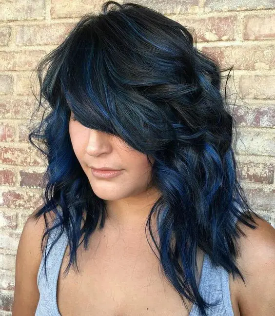 a black medium layered and shaggy haircut with dark blue balayage that brings even more dimension
