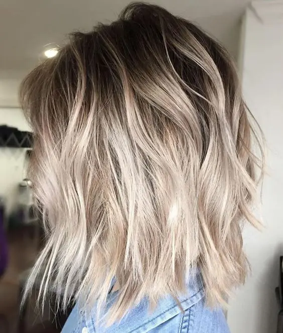 ashy blonde balayage with root fade on a shaggy bob is an edgy idea