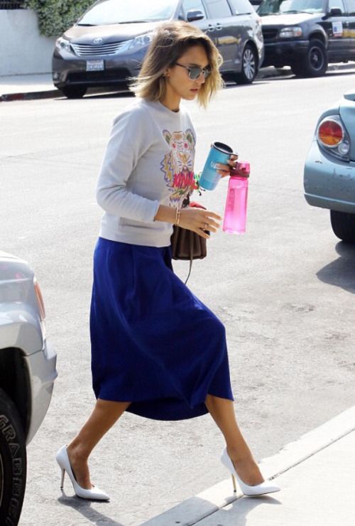an embellished sweatshirt, a bold blue midi skirt, white heels for a glam feel