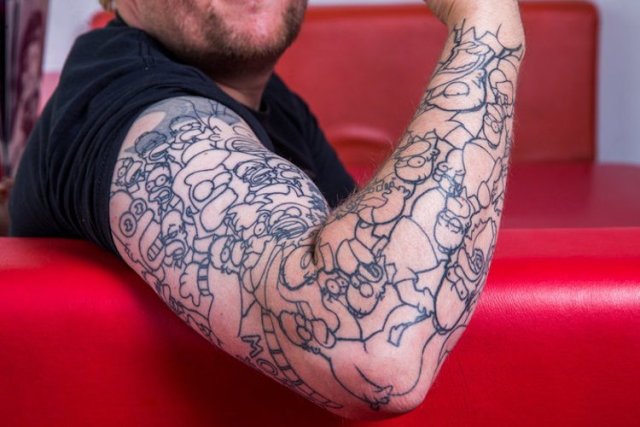 black-contour Homer Simpson tattoos on the arm