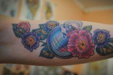 Disco ball and flowers tattoo on the forearm