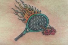 Racket and flames tattoo on the low back
