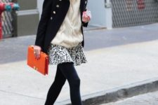 With black coat, white sweater, black and red boots and orange clutch