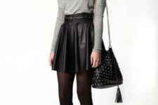 With gray shirt, black tights, black embellished boots and bag