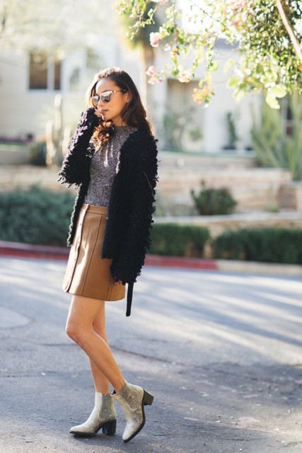 With gray shirt, fur jacket and ankle boots