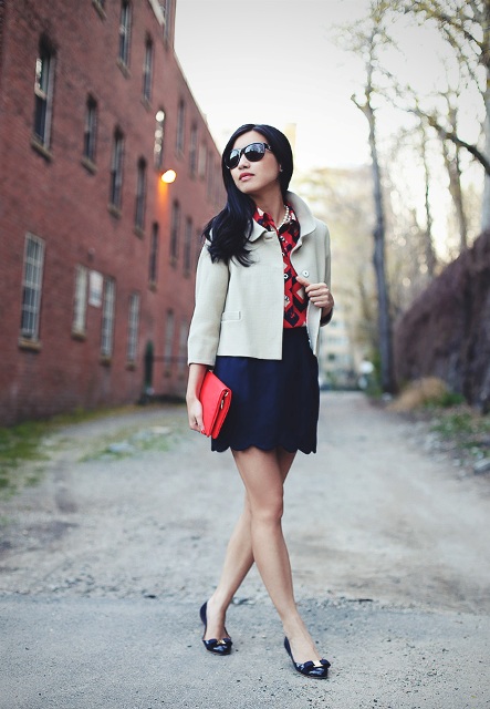With printed shirt, white jacket, black flats and red clutch