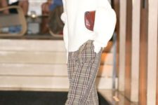 With white oversized sweater, brown clutch and checked trousers