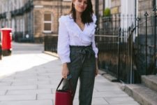 With white ruffled blouse, high-waisted trousers and red bag