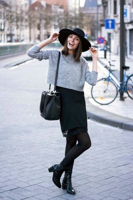 With wide brim hat, black skirt, ankle boots and black bag