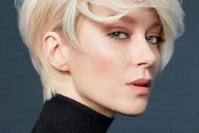 a beautiful and voluminous warm blonde long pixie cut with straight hair looks very bold and very stylish