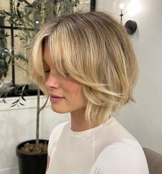 a lovely chin-length golden layered bob with curtain bangs and a lot of volume is a super eye-catchy and cool idea