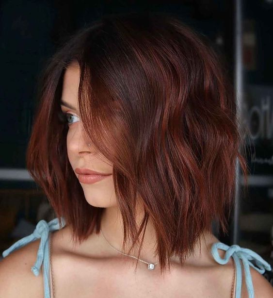 a lovely mahogany asymmetrical long bob with highlights and waves is a lovely solution to rock