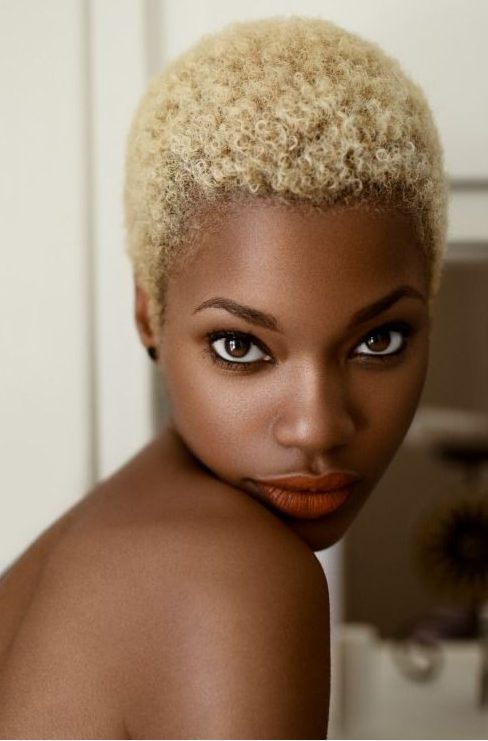A very short curly pixie haircut with Afro curls in natural blonde is a very eye catchy idea