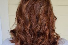 chic medium-length auburn hair with gold blonde highlights and waves down, with a lot of volume is wow