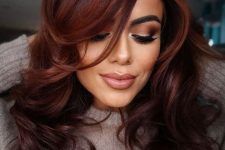 gorgeous dark auburn hair styled with a butterfly haircut, with curled ends and volume is a stylish idea to rock