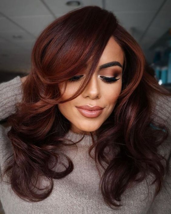 gorgeous dark auburn hair styled with a butterfly haircut, with curled ends and volume is a stylish idea to rock