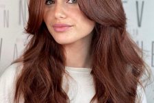 impressive long auburn hair with a lot of volume and waves, with long curtain bangs, is a super chic and catchy idea