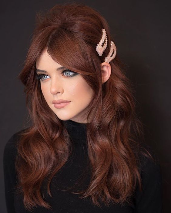 long auburn hair with a lot of volume and waves, curtain bangs and pink hairpins is a gorgeous solution to rock