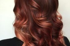 long dark auburn hair with copper and red highlights, with waves and volume, is a bold solution to make a statement