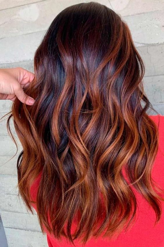 long mahogany hair with copper highlights, with waves and volume, is a stunning idea for those who love bold colors