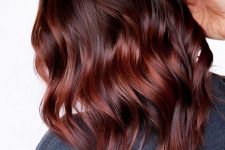 medium-length auburn hair with brighter red highlights, waves and a bit of volume is a catchy and bold idea