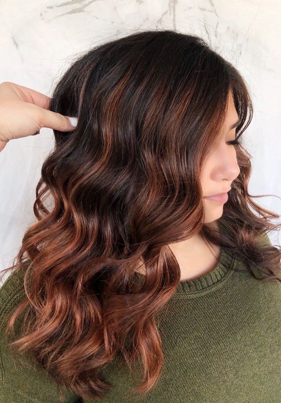 medium-length black hair with auburn ombre and balayage, with waves, is a styling and eye-catchy idea to rock