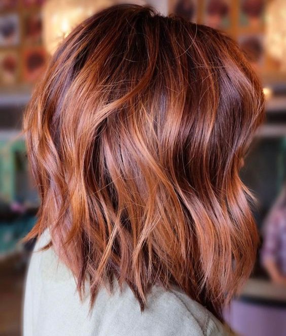 Shoulder length auburn hair with copper highlights, waves and volume, is a stunning solution to rock