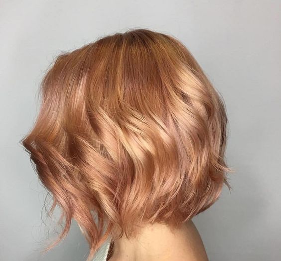 a short and shiny strawberry blonde bob with waves is a chic idea for every girl