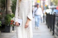 11 a chic white sweater midi dress, black flat shoes and a white clutch for winter comfort