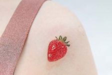 strawberry tattoo on a shoulder