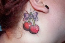 Cherry and bow tattoo behind the ear