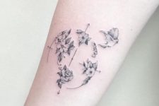 Compass, bird and flowers tattoo on the arm