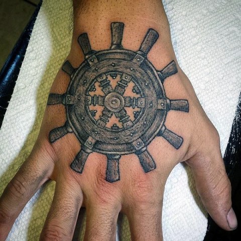 Detailed ship wheel tattoo on the hand