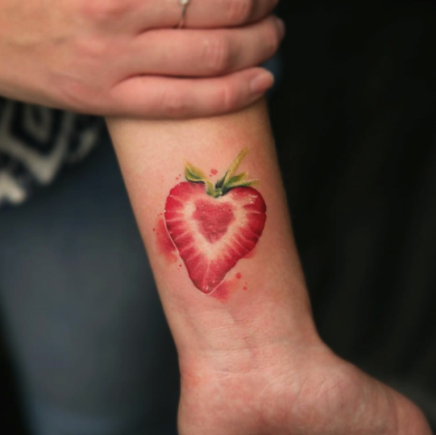 Half of a strawberry tattoo on the wrist