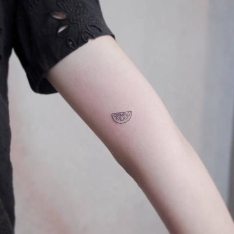 Lemon slice tattoo on the forearm