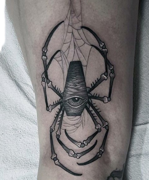 One eyed spider tattoo on the forearm