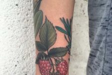 Pink raspberry and green leaves tattoo on the forearm