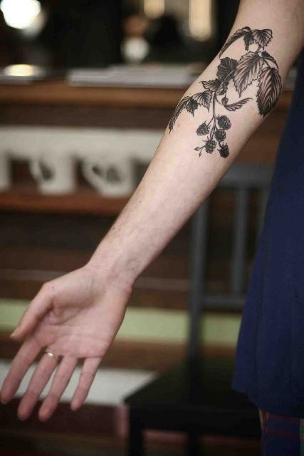 Raspberry and leaves tattoo on the arm