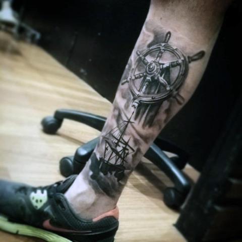 Realistic ship wheel and ship tattoo on the leg