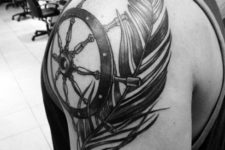 Ship wheel and feather tattoo on the shoulder