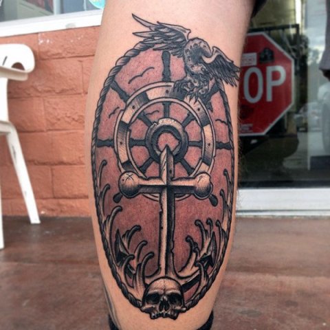 Ship wheel and skull tattoo on the leg