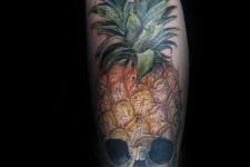 Skull and pineapple tattoo on the leg