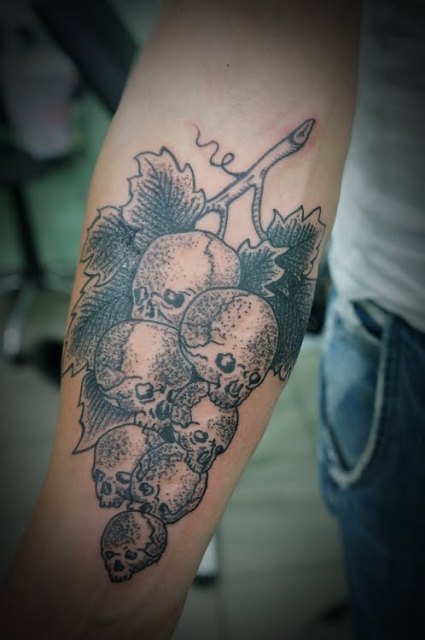 Skull grapes tattoo on the forearm