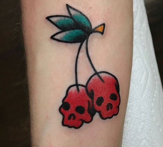 Skull shaped cherry tattoo on the hand