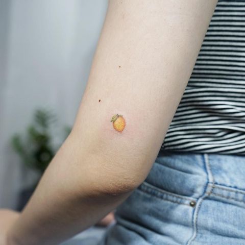 Tiny lemon tattoo on the arm