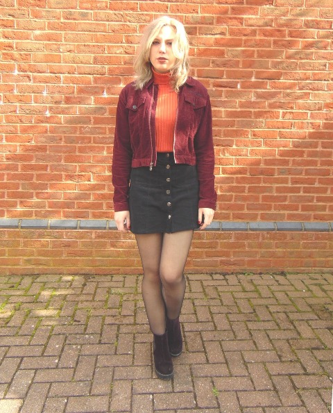 With orange turtleneck, black mini skirt and suede boots
