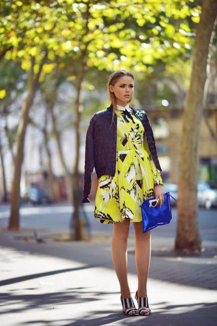 With printed dress, black and white shoes and blue clutch