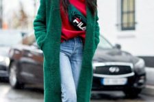 With red loose sweatshirt, crop jeans, green coat and white ankle boots