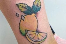 Yellow lemon and green leaves tattoo on the leg